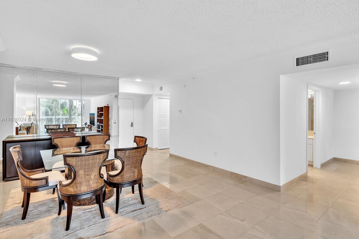 8855 Collins Avenue, Unit 2F Surfside, FL 33154 - Photo 35 of 79 a dining area with furniture and a large window