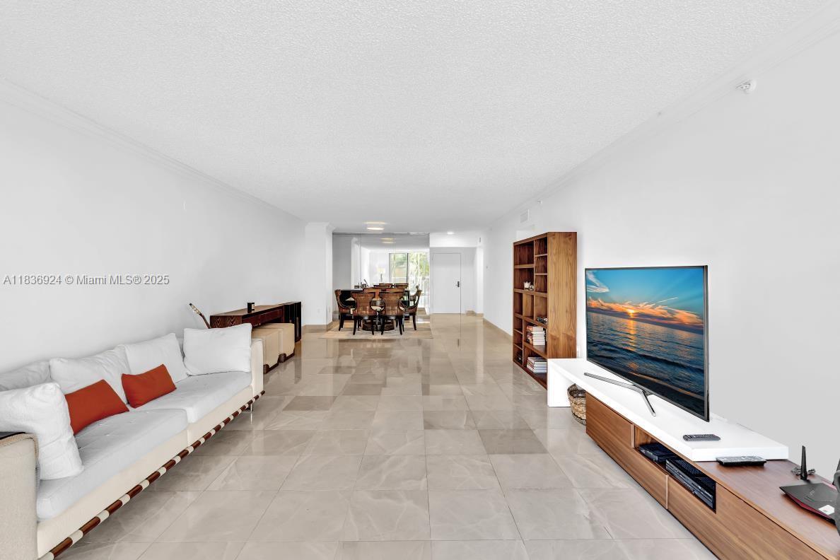 8855 Collins Avenue, Unit 2F Surfside, FL 33154 - Photo 39 of 79 a living room with furniture and a flat screen tv