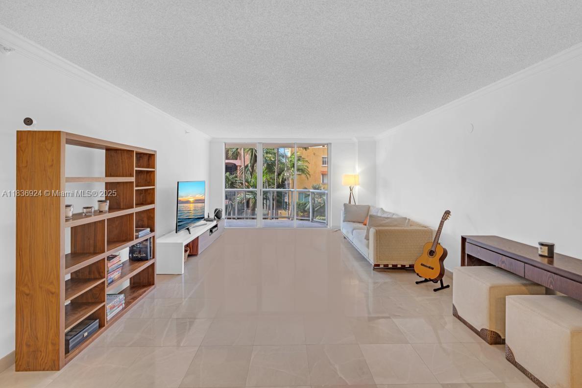 8855 Collins Avenue, Unit 2F Surfside, FL 33154 - Photo 46 of 79 a living room with furniture and a book shelf