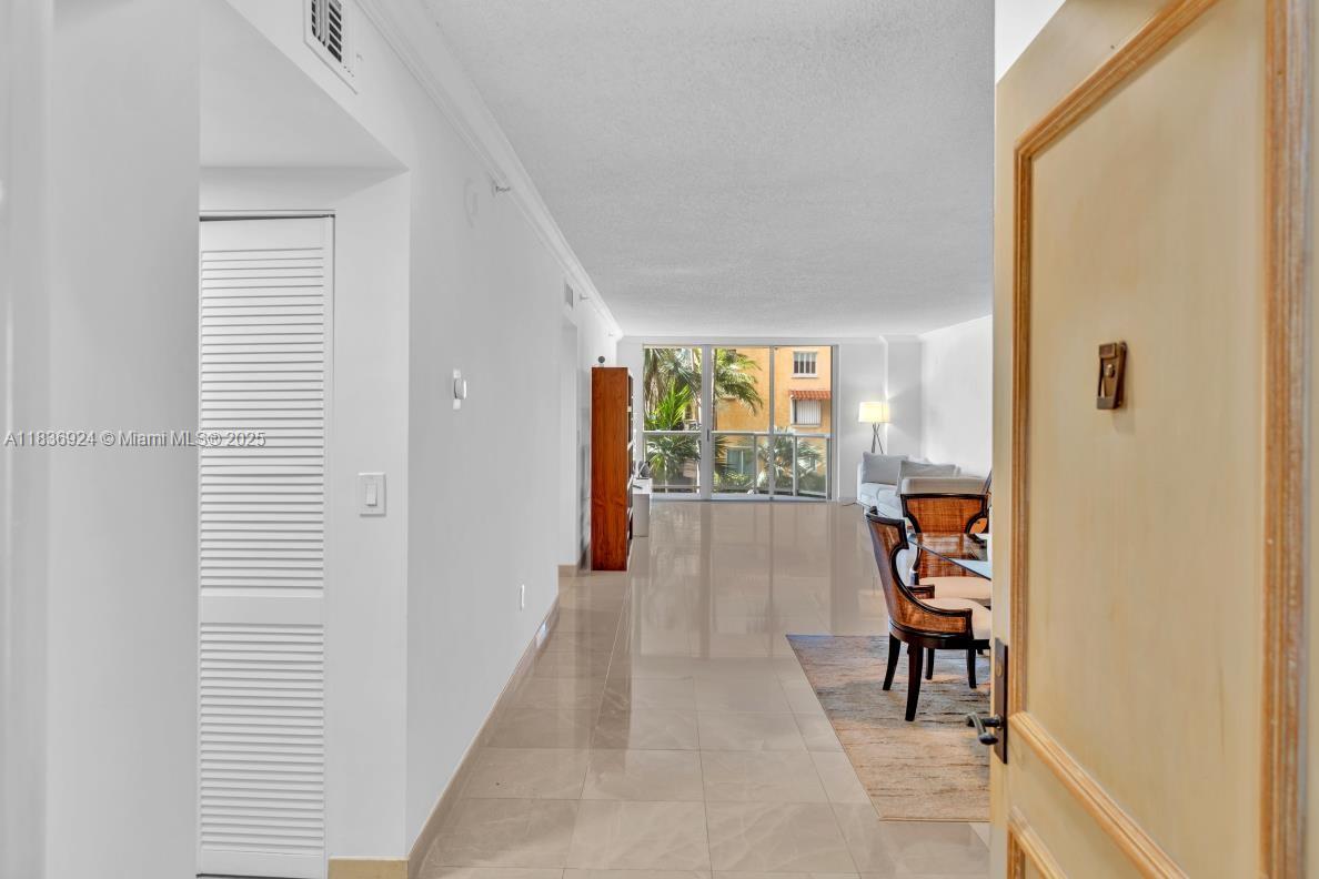 8855 Collins Avenue, Unit 2F Surfside, FL 33154 - Photo 49 of 79 a view of a hallway with wooden floor and a bedroom