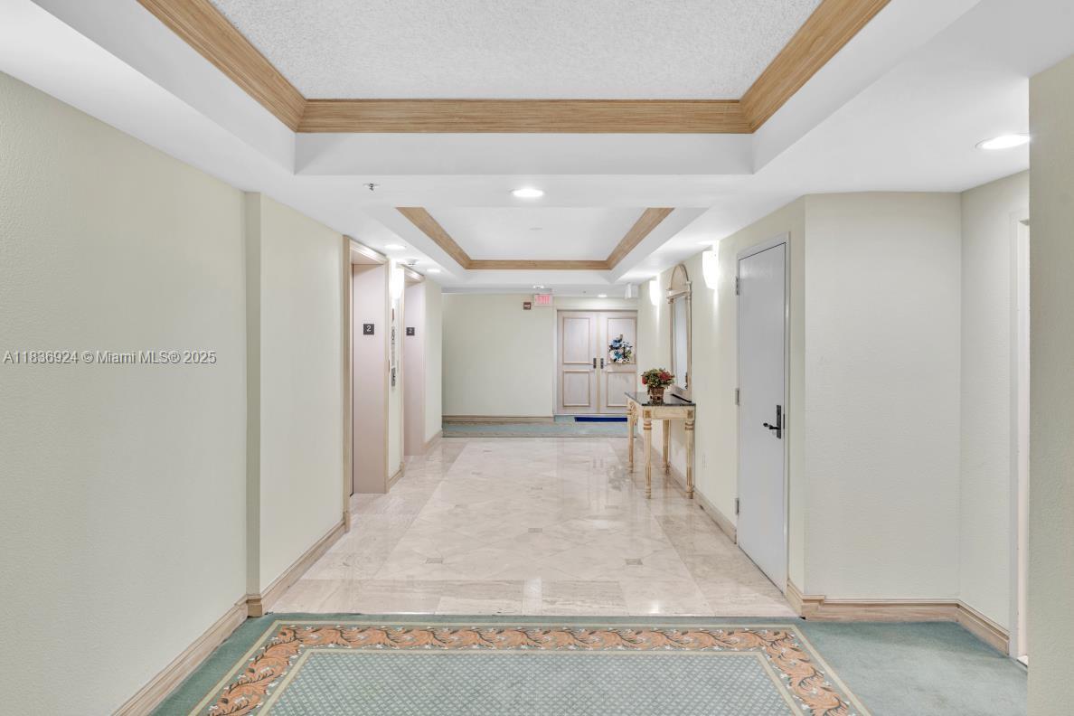 8855 Collins Avenue, Unit 2F Surfside, FL 33154 - Photo 53 of 79 a view of a hallway with a furniture and a rug