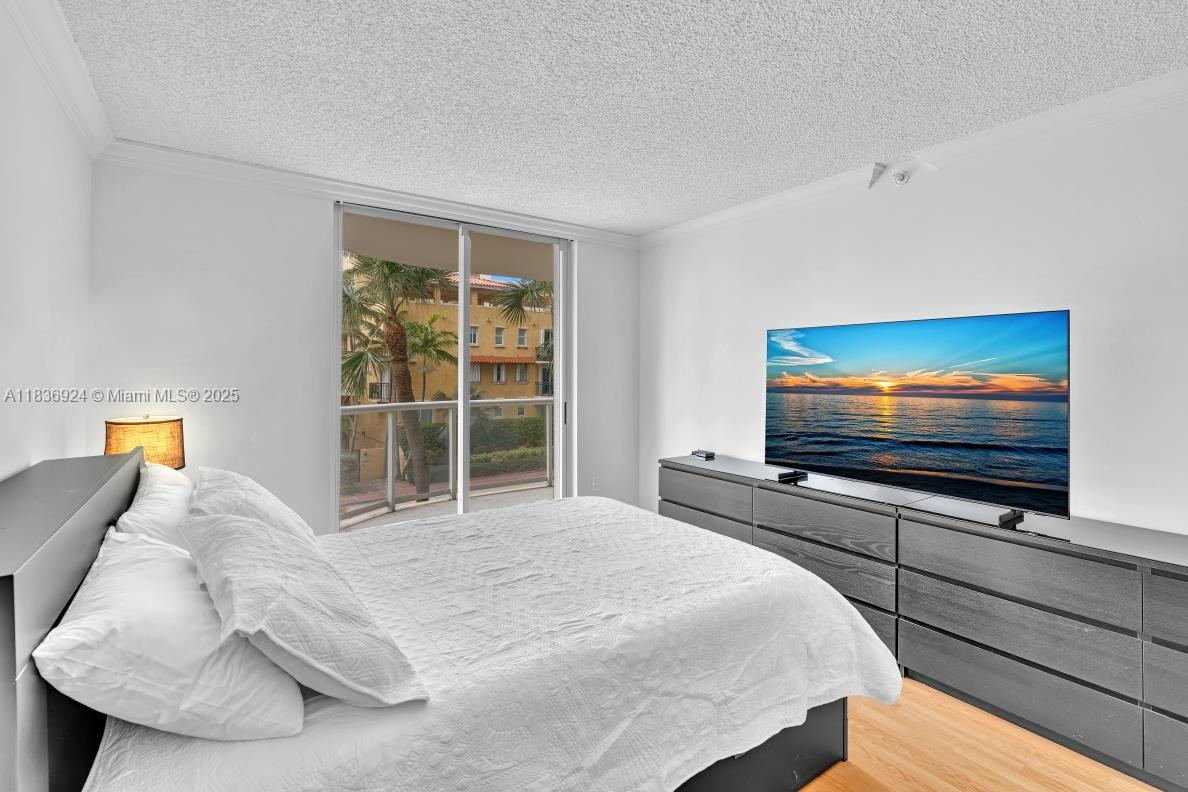 8855 Collins Avenue, Unit 2F Surfside, FL 33154 - Photo 62 of 79 a bedroom with a bed and a flat screen tv