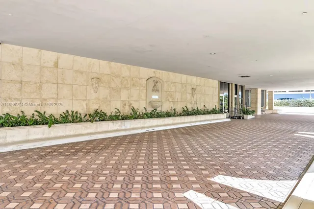 a view of a dining room with furniture a chandelier and large windows
