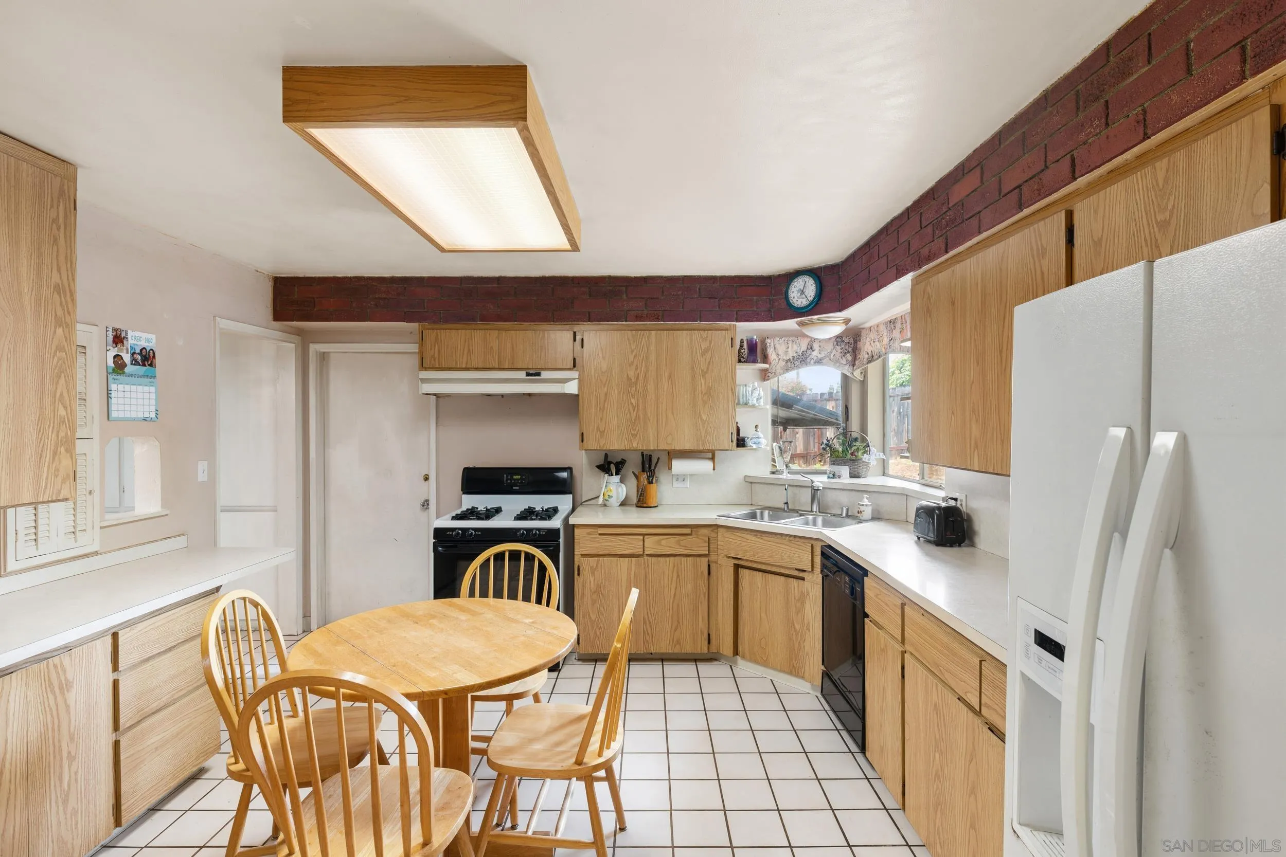 9361 Hollyhock Lane Spring Valley, CA 91977 - Photo 11 of 31 a kitchen with a table chairs sink and cabinets