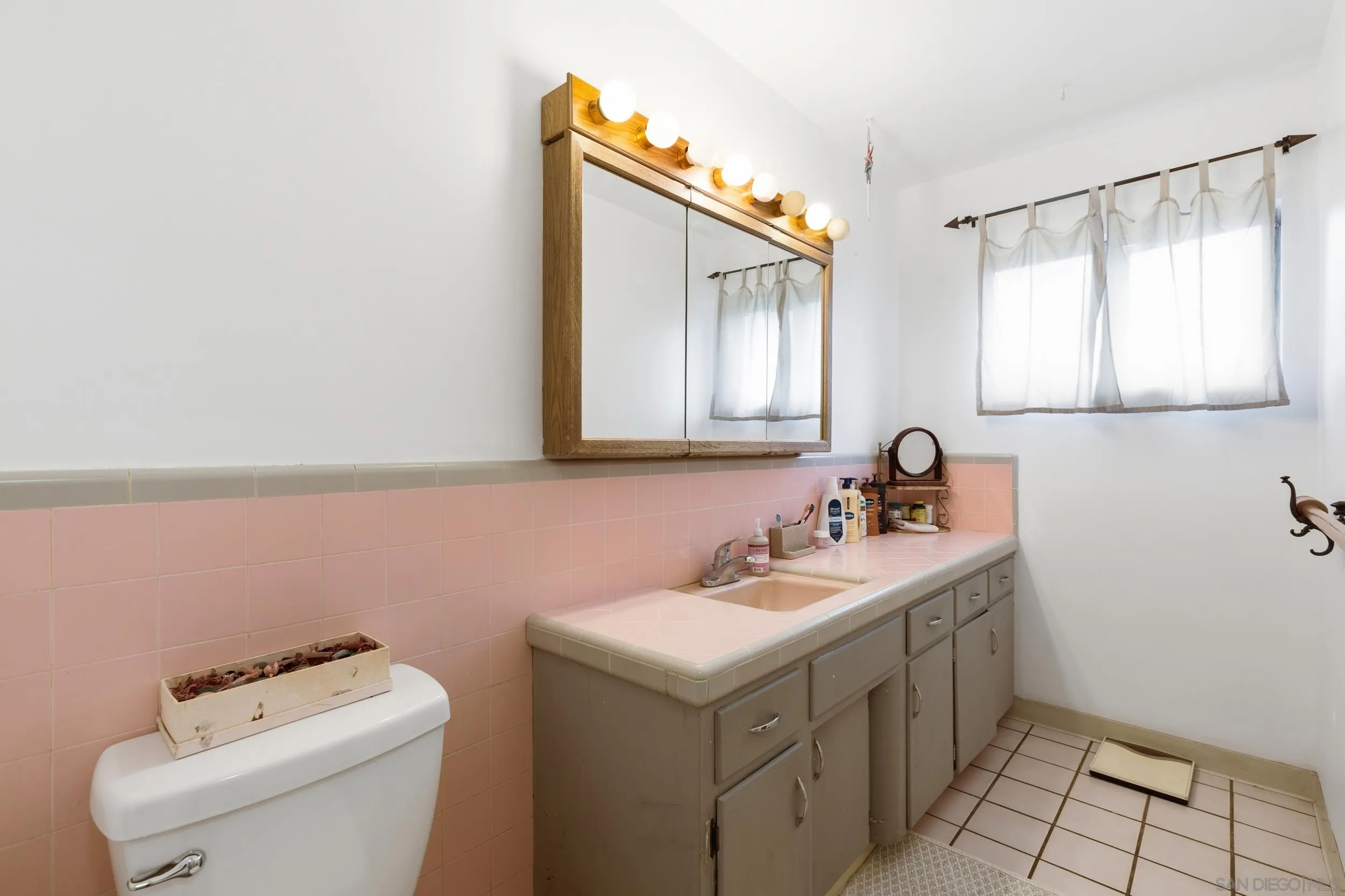 9361 Hollyhock Lane Spring Valley, CA 91977 - Photo 14 of 31 a bathroom with a sink toilet and mirror