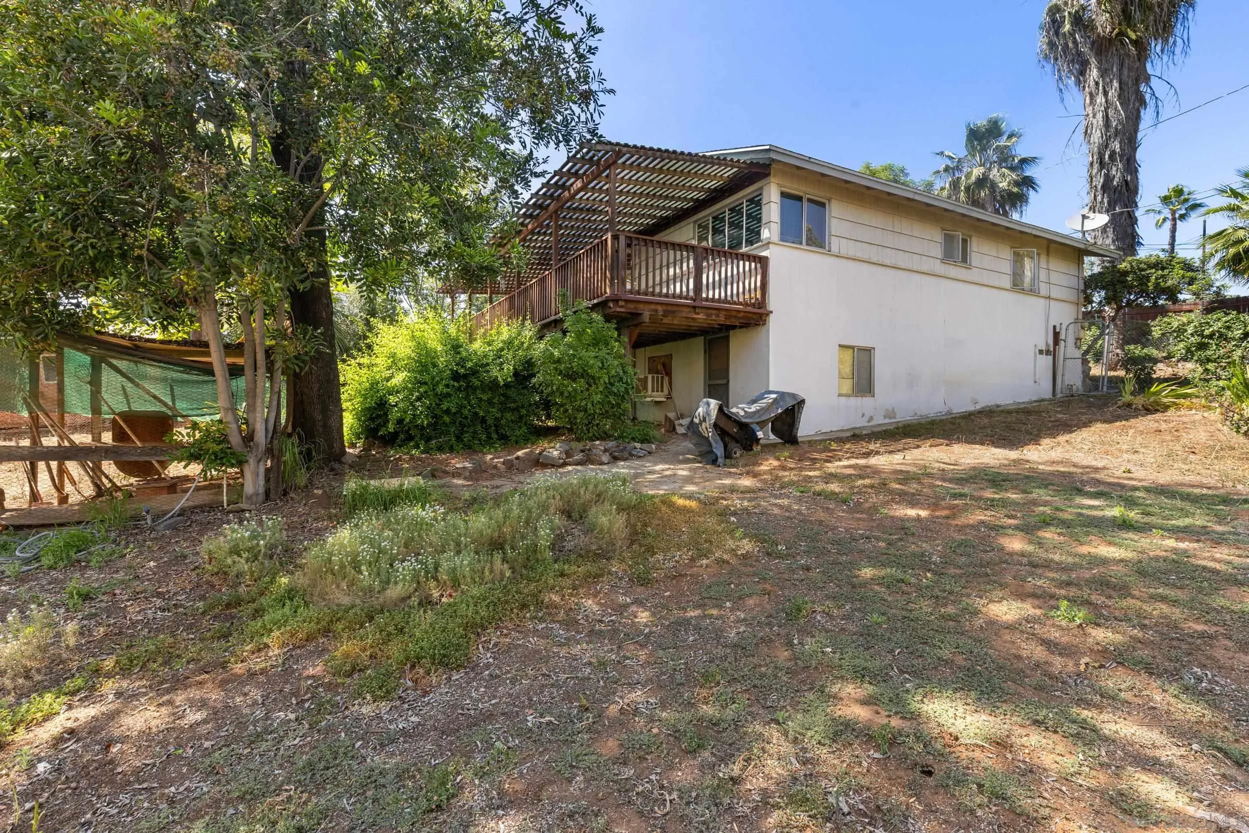 9361 Hollyhock Lane Spring Valley, CA 91977 - Photo 23 of 31 a view of a white house with a big yard and large trees