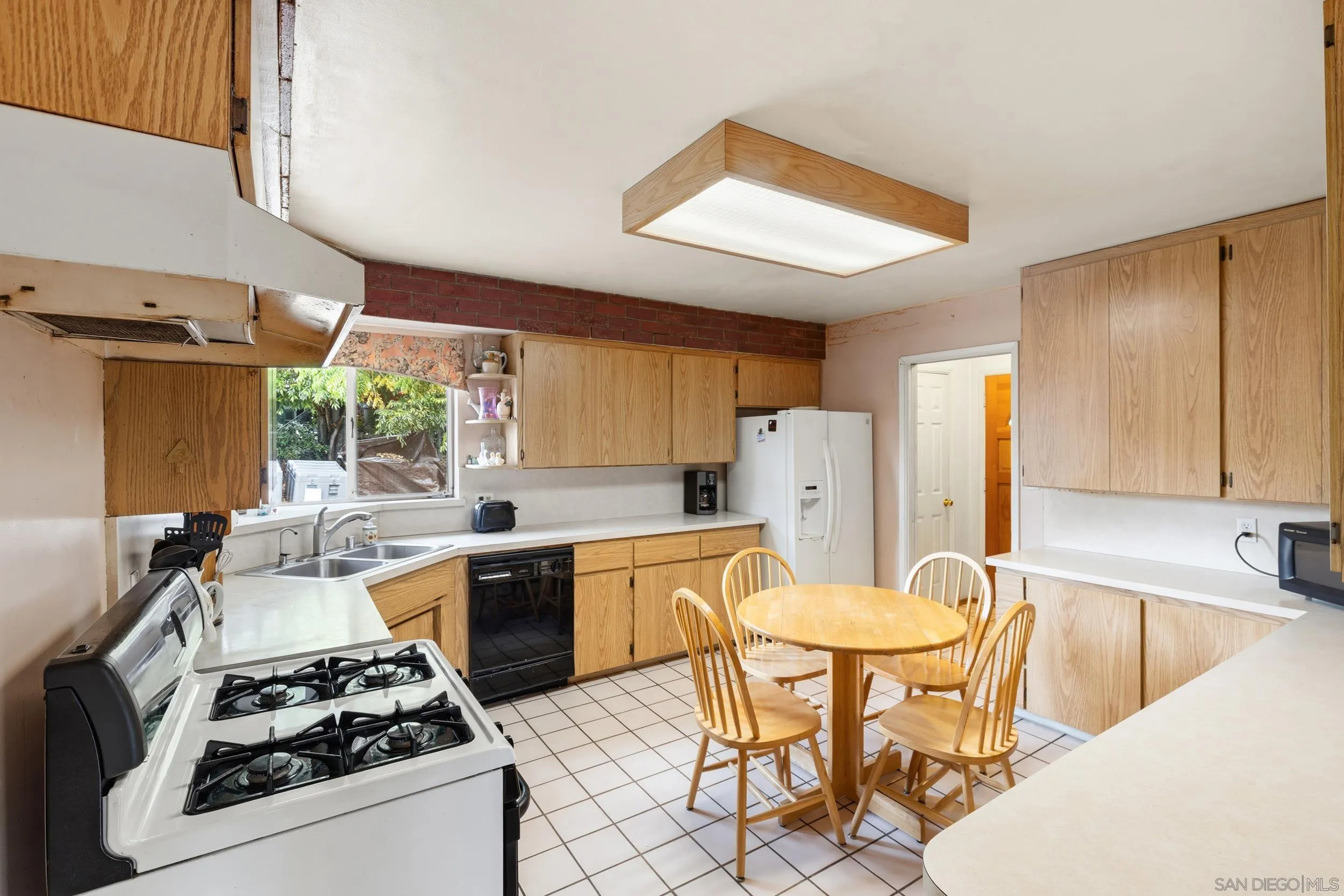 9361 Hollyhock Lane Spring Valley, CA 91977 - Photo 9 of 31 a kitchen with a stove a sink and a refrigerator