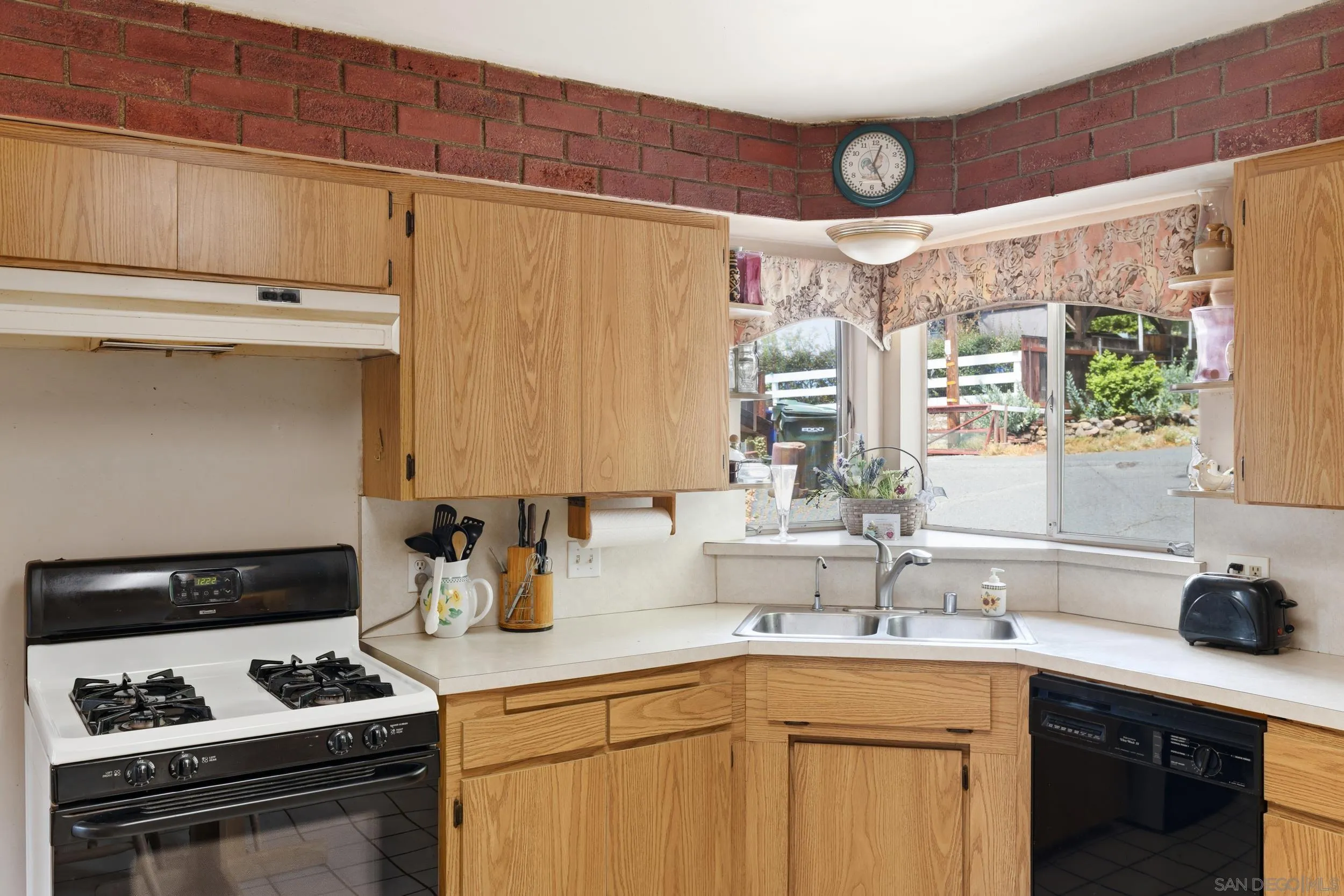 9361 Hollyhock Lane Spring Valley, CA 91977 - Photo 10 of 31 a kitchen with stainless steel appliances a sink a stove and white cabinets