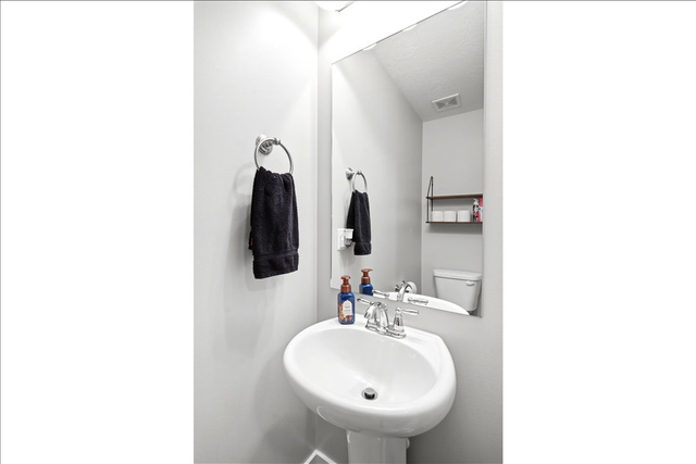 2973 West Red Sand Rd Haven Ogden, UT 84401 - Photo 23 of 30 Pedestal sink with chrome faucet, large frameless mirror, and wall-mounted towel ring