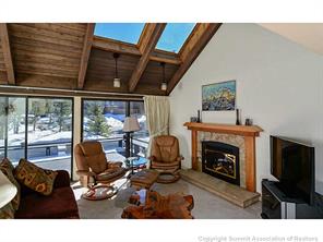 1446 Broken Lance Drive, Unit 3 Breckenridge, CO 80424 - Photo 1 of 25 a living room with furniture a fireplace and a floor to ceiling window