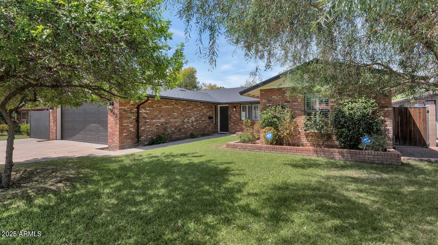 a view of a house with backyard and a tree