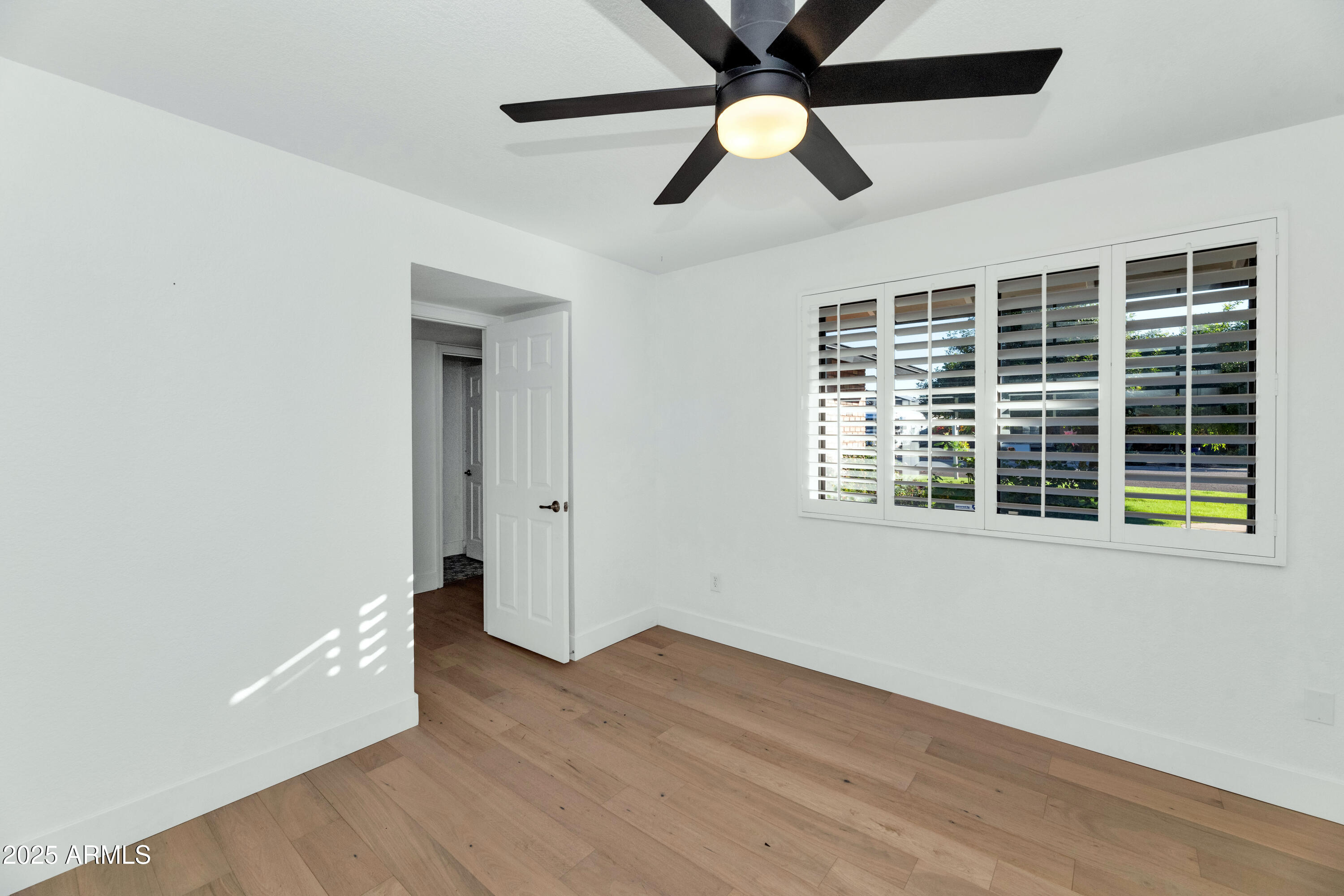 4642 North 31st Street Phoenix, AZ 85016 - Photo 30 of 50 an empty room with wooden floor fan and windows