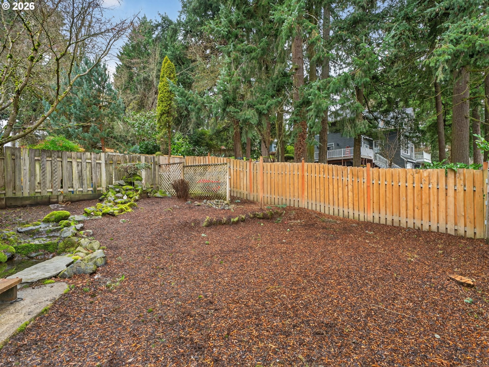 6805 Southwest 180th Avenue Beaverton, OR 97007 - Photo 29 of 29 a backyard of a house with large trees and wooden fence