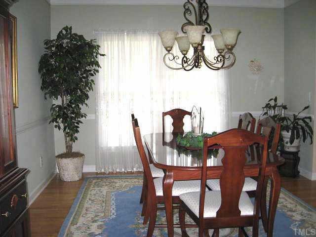 9116 Breeland Way Raleigh, NC 27613 - Photo 4 of 12 a view of a dining room with furniture window and wooden floor