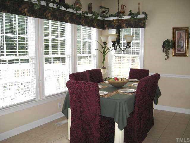 9116 Breeland Way Raleigh, NC 27613 - Photo 6 of 12 a view of a dining room with furniture and windows