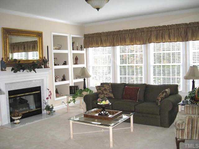 9116 Breeland Way Raleigh, NC 27613 - Photo 8 of 12 a living room with furniture a flat screen tv and a fireplace
