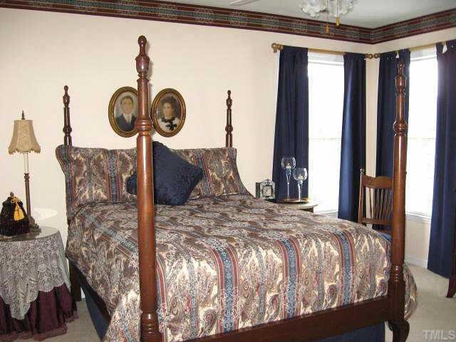 9116 Breeland Way Raleigh, NC 27613 - Photo 10 of 12 a bed sitting in a bedroom next to a window