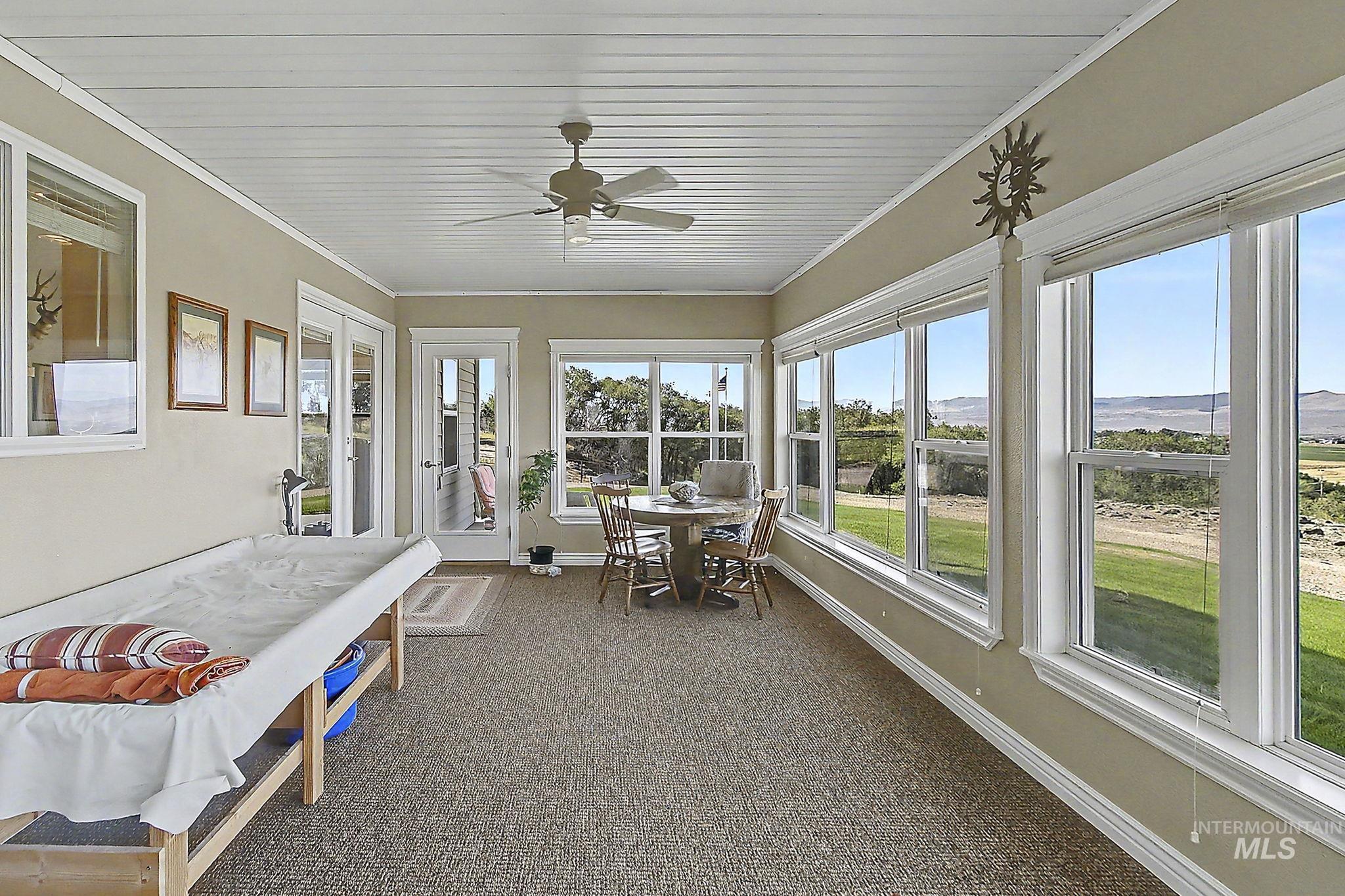 6900 West Charters Lane Melba, ID 83641 - Photo 22 of 49 Spacious sunroom featuring multiple large windows, French doors, a paneled ceiling, and a ceiling fan