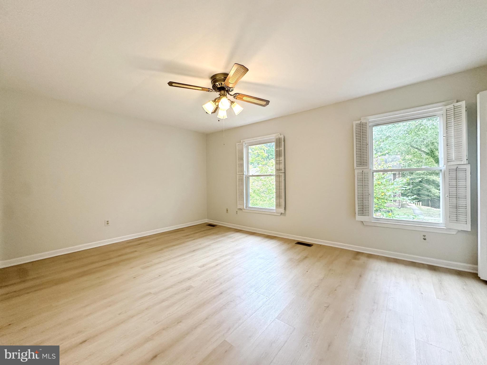 6260 Rathlin Drive Springfield, VA 22152 - Photo 16 of 27 an empty room with wooden floor fan and windows