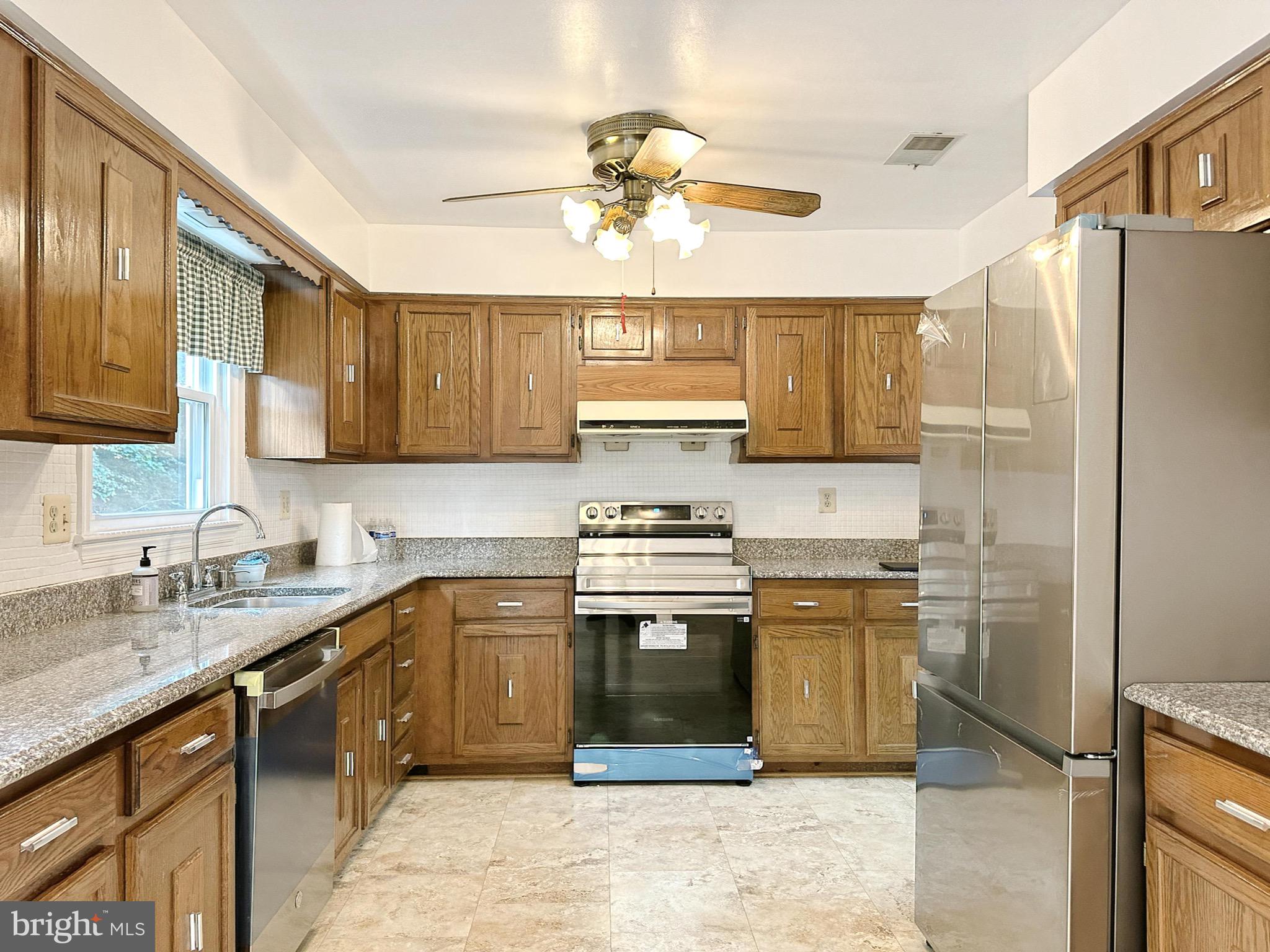 6260 Rathlin Drive Springfield, VA 22152 - Photo 9 of 27 a kitchen with stainless steel appliances granite countertop a sink stove and refrigerator