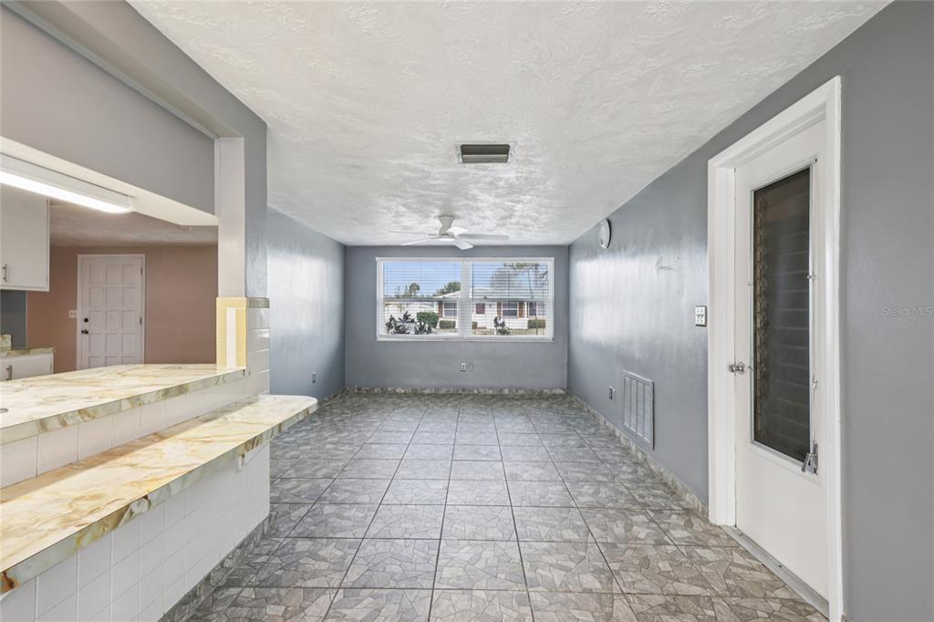 3548 Darlington Road Holiday, FL 34691 - Photo 11 of 32 a large white kitchen with granite countertop a sink and a large mirror
