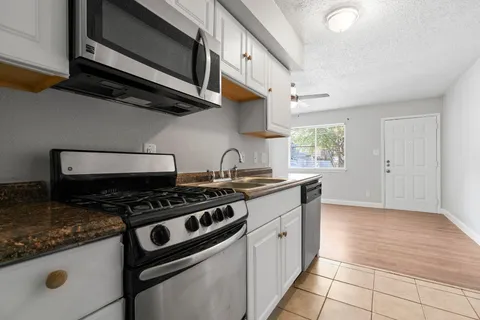a kitchen with stainless steel appliances granite countertop a stove and a sink