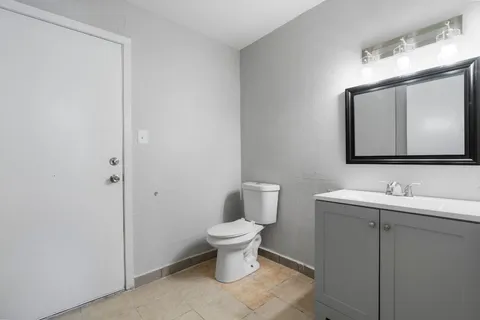 a bathroom with a toilet sink and mirror