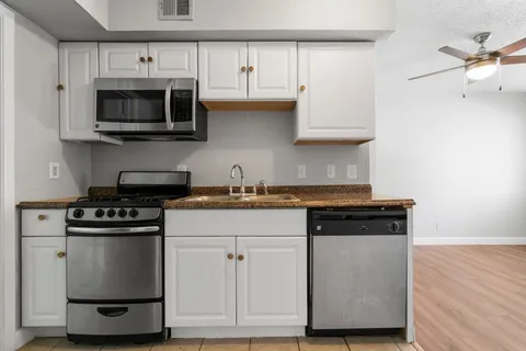 a kitchen with stainless steel appliances granite countertop a stove and a microwave