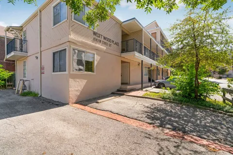 a view of a white house with a yard and large tree