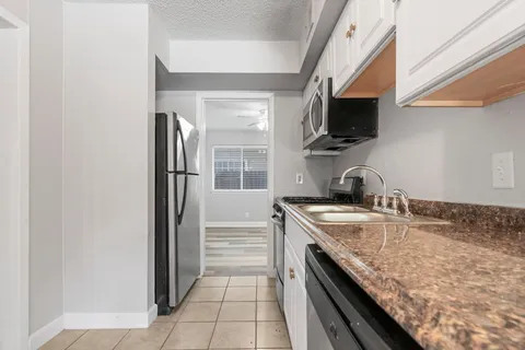 a kitchen with stainless steel appliances granite countertop a sink stove and microwave