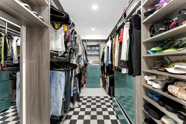 a view of walk in closet with clothes and shoes