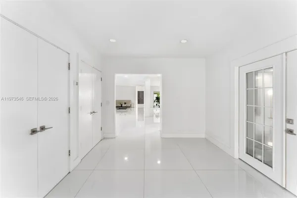 a view of a hallway with white walls and chandelier