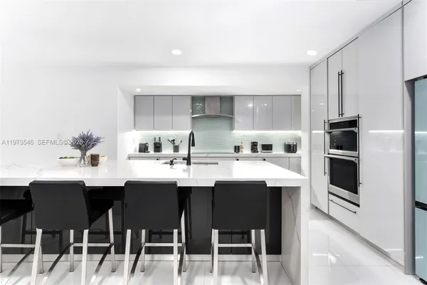 a kitchen with stainless steel appliances kitchen island a sink table and chairs