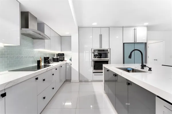 a large kitchen with stainless steel appliances kitchen island granite countertop a sink and cabinets