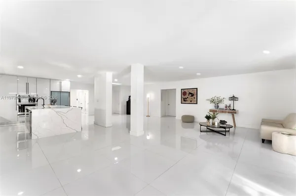 a living room with furniture and a refrigerator
