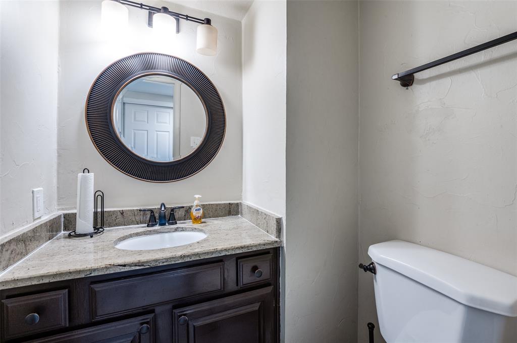 18240 Midway Road, Unit 1704 Dallas, TX 75287 - Photo 18 of 25 a bathroom with a granite countertop toilet sink and mirror