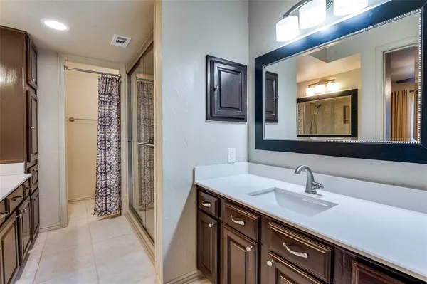 a bathroom with a shower sink and mirror