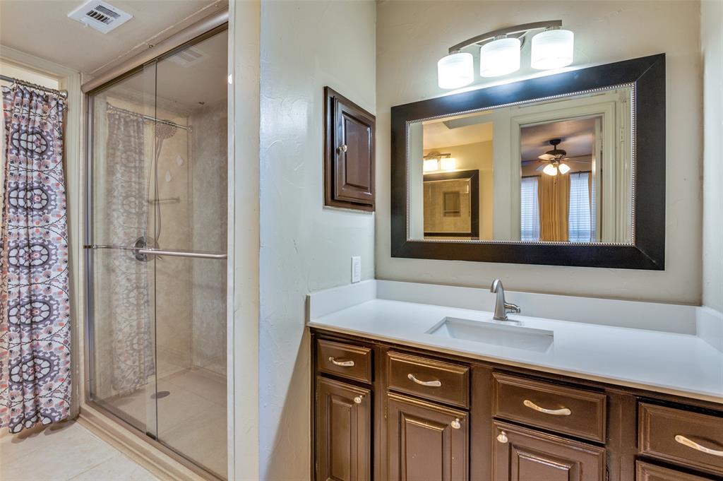18240 Midway Road, Unit 1704 Dallas, TX 75287 - Photo 23 of 25 a bathroom with a shower sink and mirror