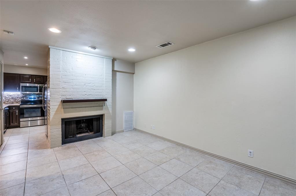18240 Midway Road, Unit 1704 Dallas, TX 75287 - Photo 6 of 25 an empty room with kitchen view and fireplace