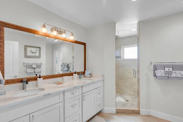 a bathroom with a sink a toilet a shower and a mirror