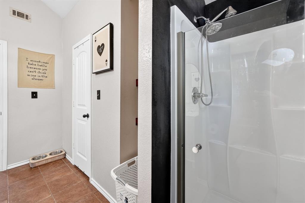 810 Edna Street Athens, TX 75751 - Photo 21 of 28 Shower enclosure featuring a chrome showerhead with a handheld sprayer, white paneling, and a clear glass door