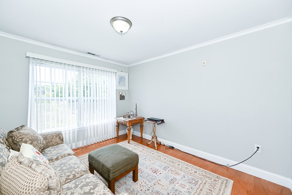 84 Mill Street, Unit 304 Woonsocket, RI 02895 - Photo 19 of 25 a bedroom with a bed and wooden floor