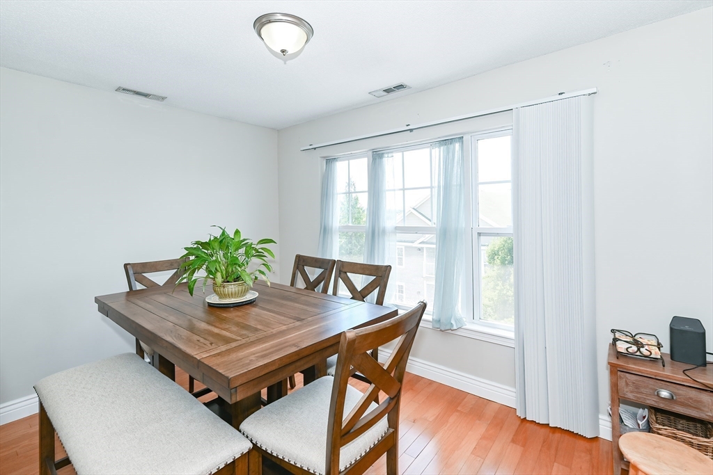 84 Mill Street, Unit 304 Woonsocket, RI 02895 - Photo 6 of 25 a dining room with furniture and wooden floor