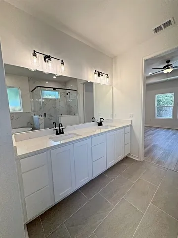 a bathroom with a double vanity sink and mirror