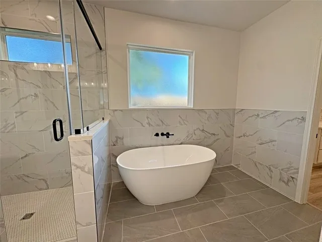 a bathroom with a bathtub and shower