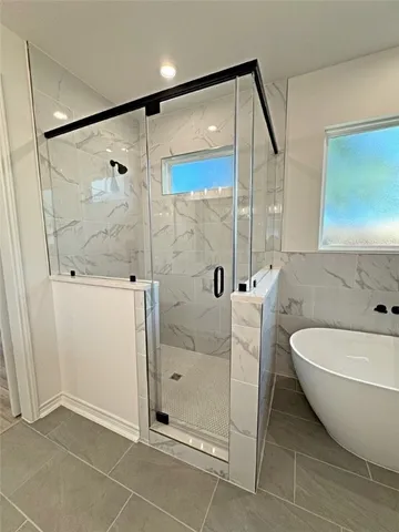 a spacious bathroom with a glass shower door and a sink