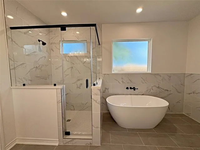 a bathroom with a bathtub and shower