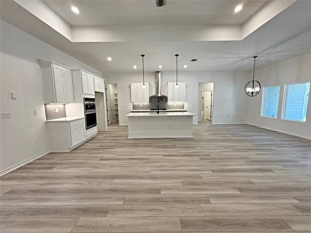an open kitchen with white cabinets and stainless steel appliances