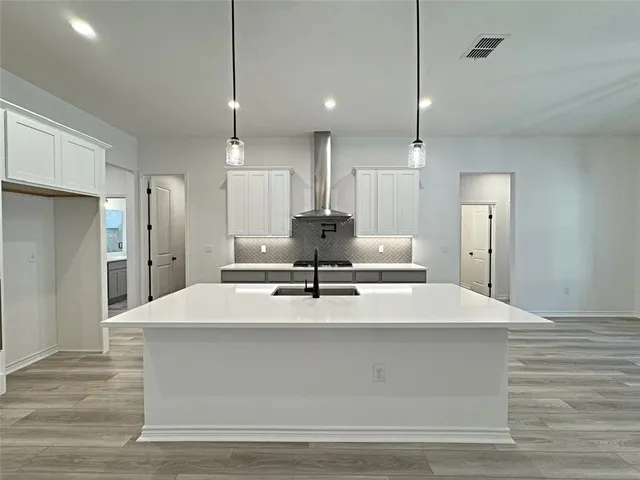 a large kitchen with stainless steel appliances kitchen island a refrigerator and a view of living room
