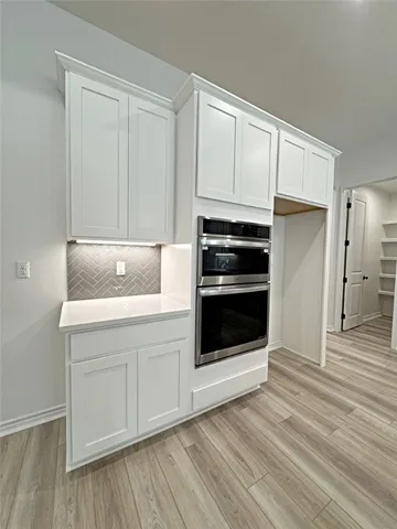 a kitchen with white cabinets and stainless steel appliances